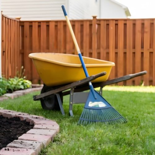The backyard garden box of a residential home with black mulch in between the house and the brick pavers.