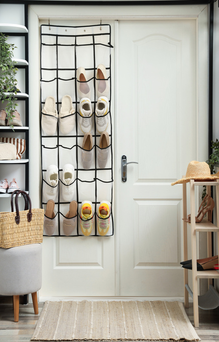 A white double door features hanging shoe storage, tall white shelves on one side, and a smaller shelf on the other.