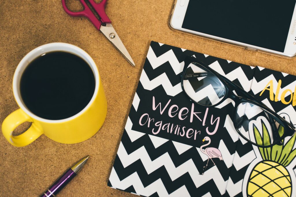Weekly Organizer flat lay calendar with yellow cup of coffee, black. How to stay organized with ADHD
